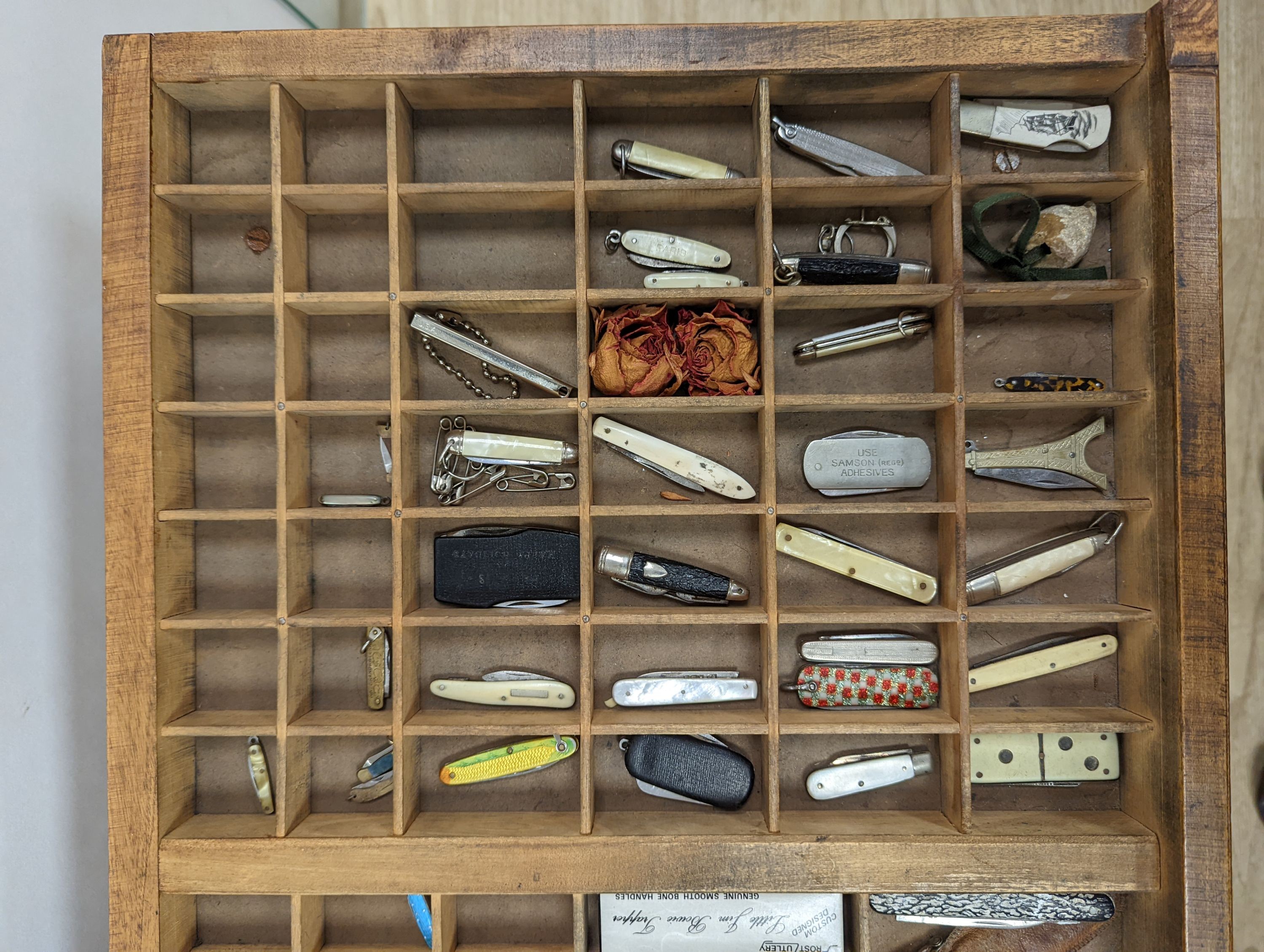 A collection of 19th century and later pen and fruit knives mounted in a coffee table